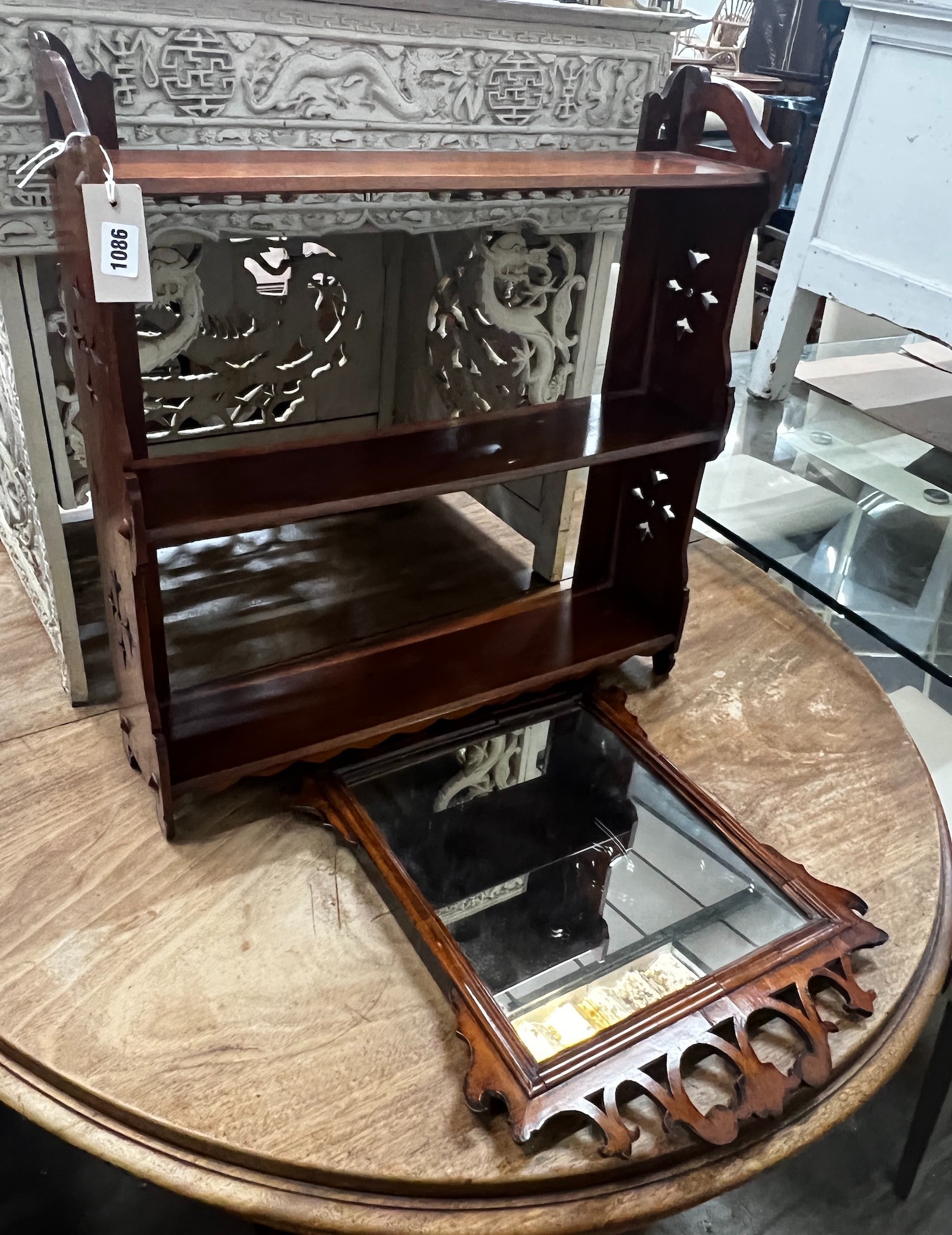 A Victorian mahogany three tier wall bracket, width 61cm height 63cm, and a small walnut fret cut wall mirror, height 52cm